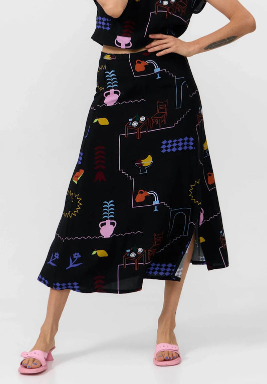 Woman wearing a black skirt with colorful geometric pattern on a white background