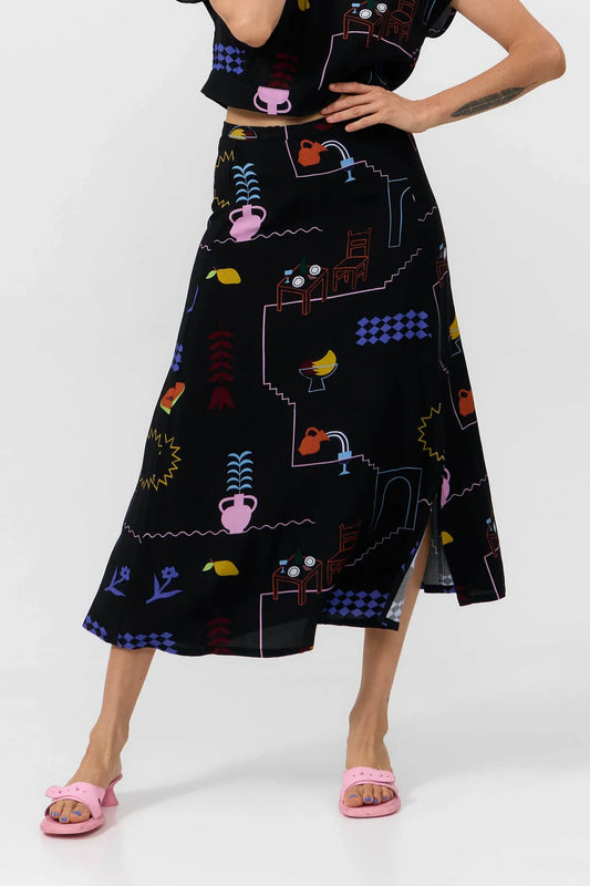 Woman wearing a black skirt with colorful geometric pattern on a white background