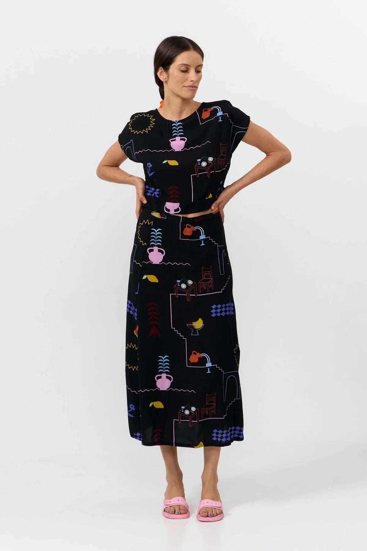 Woman wearing a black dress with colorful patterns on a white background