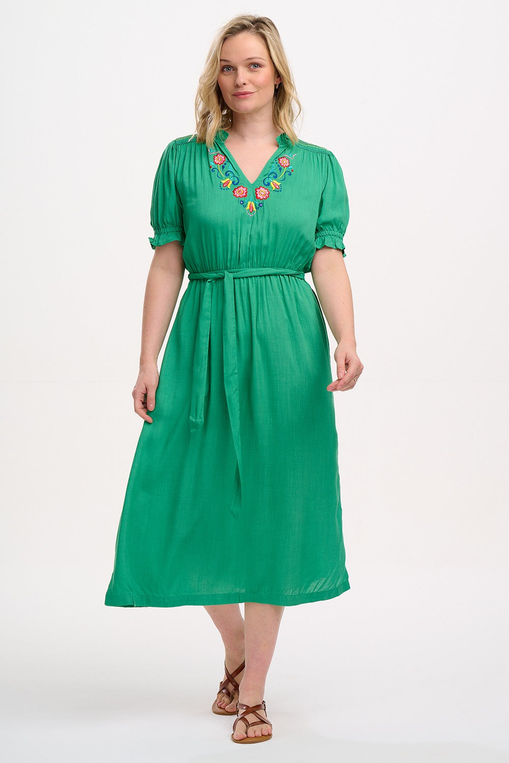 Boho style summer midi dress from SUGARHILL BRIGHTON in a vibrant shade of green. It has a relaxed cut and comes with a self-fabric belt, short sleeves with shirred frill cuffs, shirring on the shoulders, a flattering V-neck adorned with delicate floral embroidery.l and pockets.