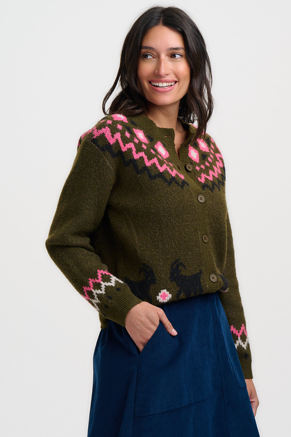 Woman wearing an olive green fair isle cardigan from Sugarhill Brighton with a bright pink floral pattern in folk style 