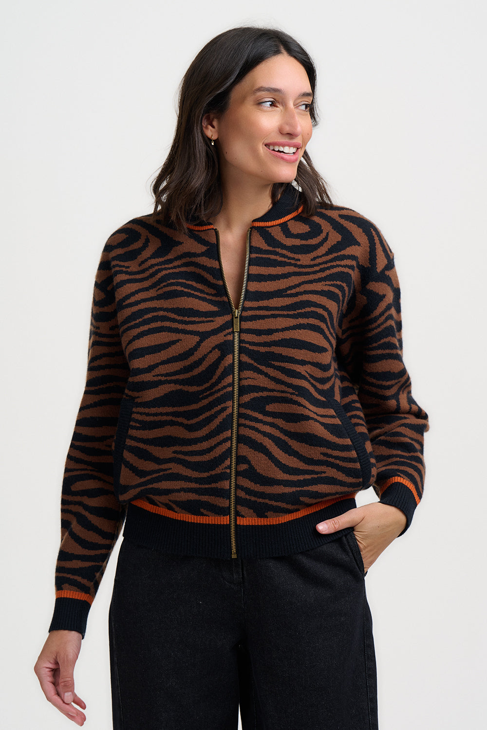 Woman wearing the tiger print zip-up bomber jacket Solana by Sugarhill Brighton against a white background
