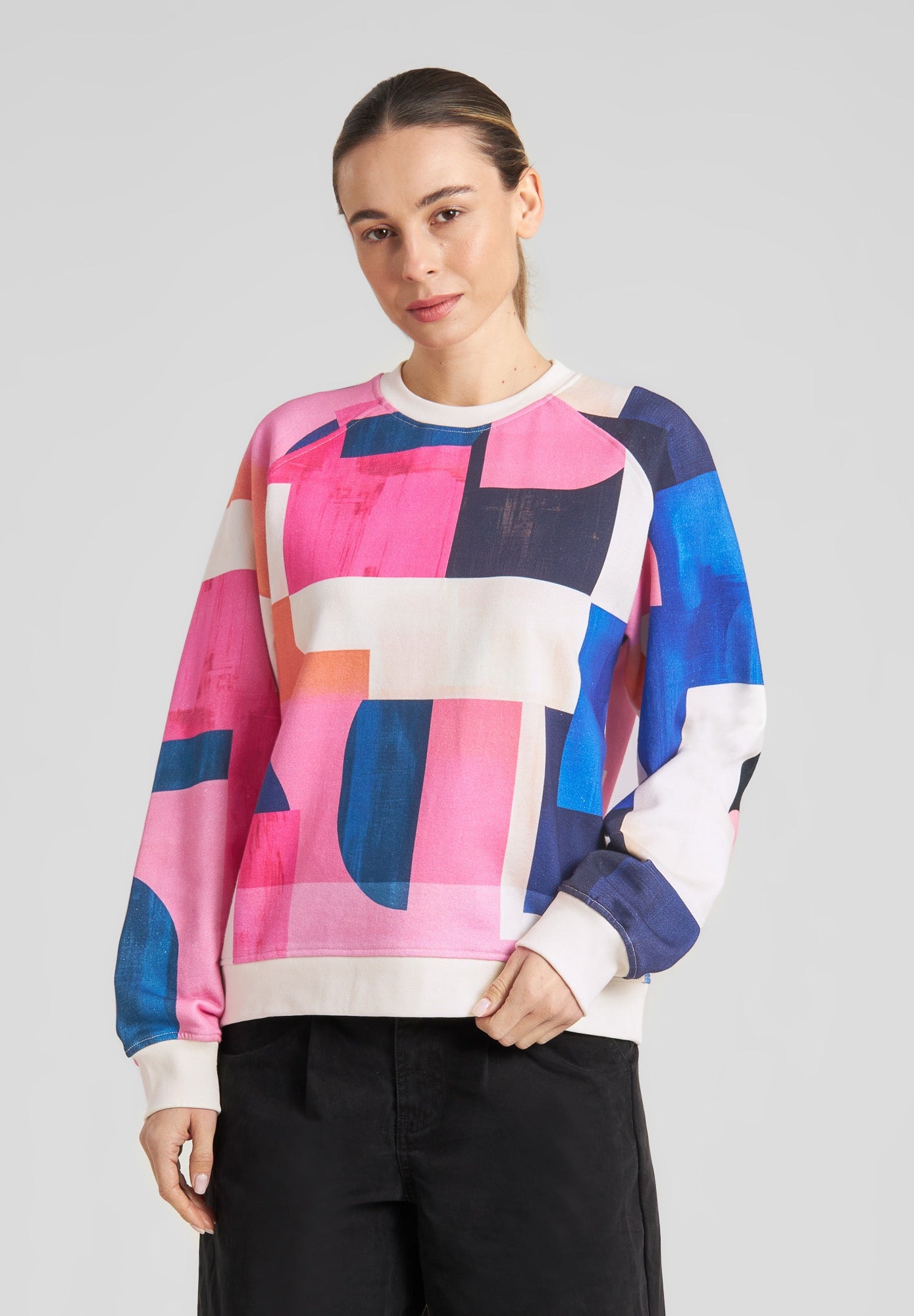 Person wearing a colorful geometric-patterned sweater on a plain background