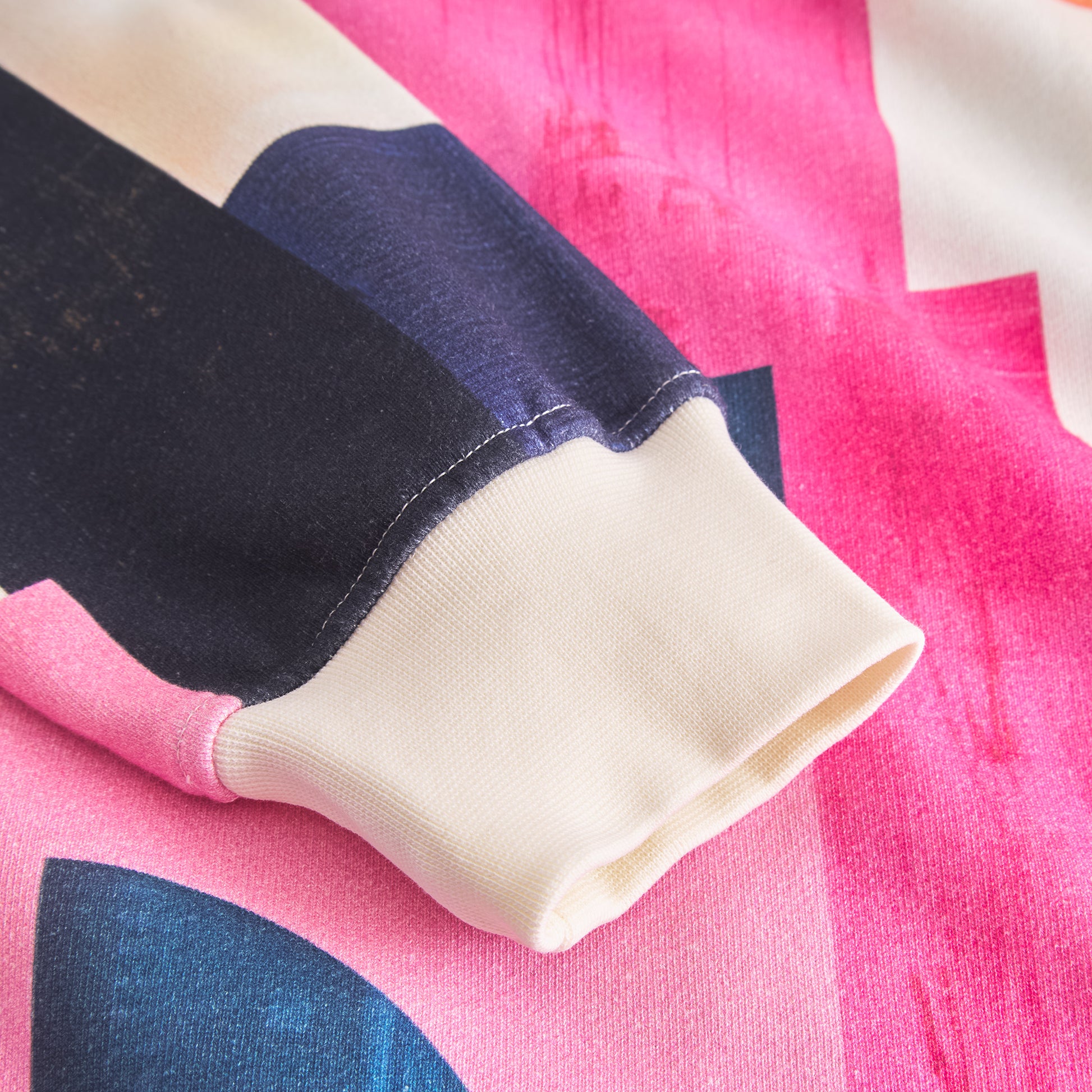 Close-up of a sleeve with pink, blue, and white pattern on a matching fabric background