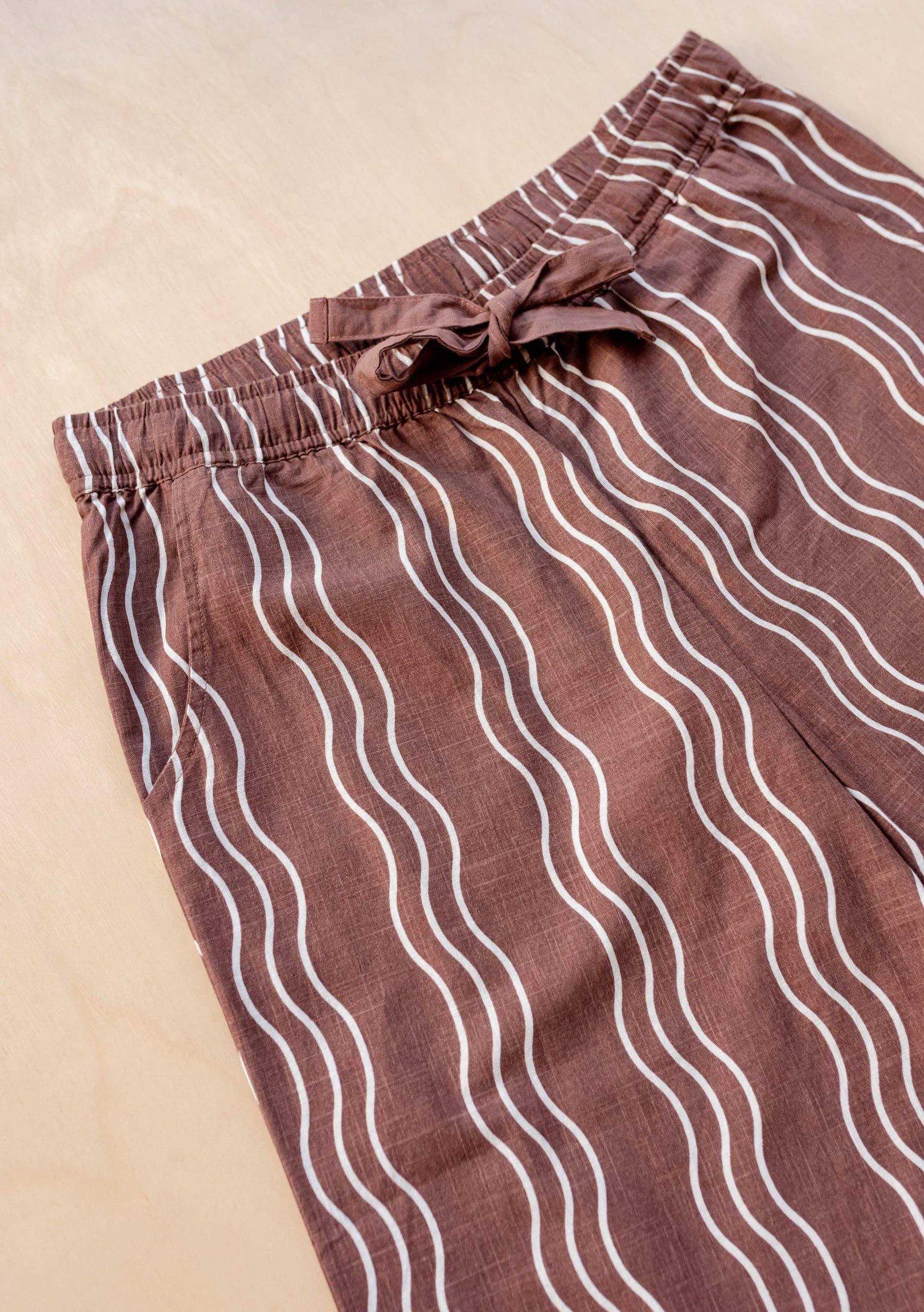 Brown pants with white wavy lines on a beige background